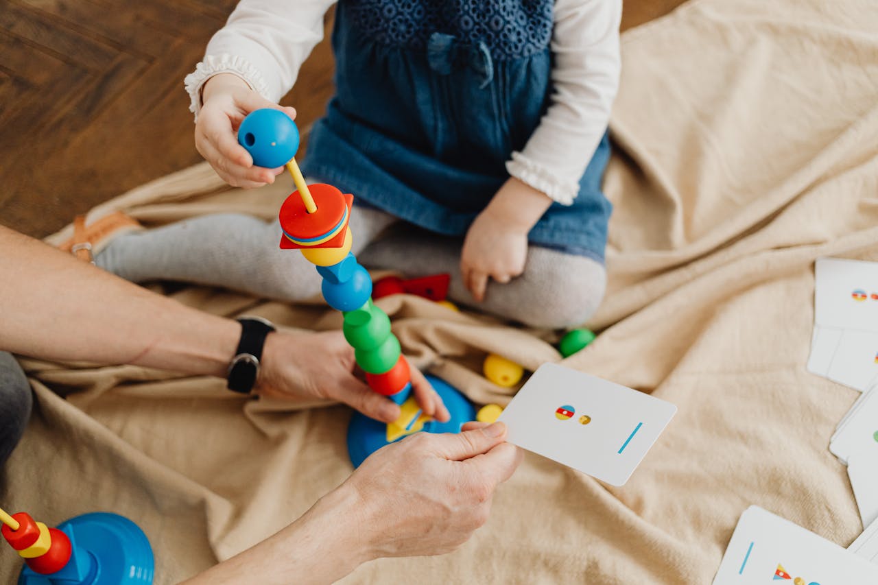 A child playing with colorful educational toys and flashcards indoors.